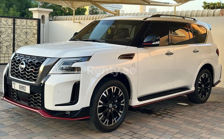 Perle blanche Nissan Patrol en location à Abu-Dhabi